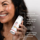 Woman holding a bottle of Elta MD UV Daily SPF 40 sunscreen with product features listed.