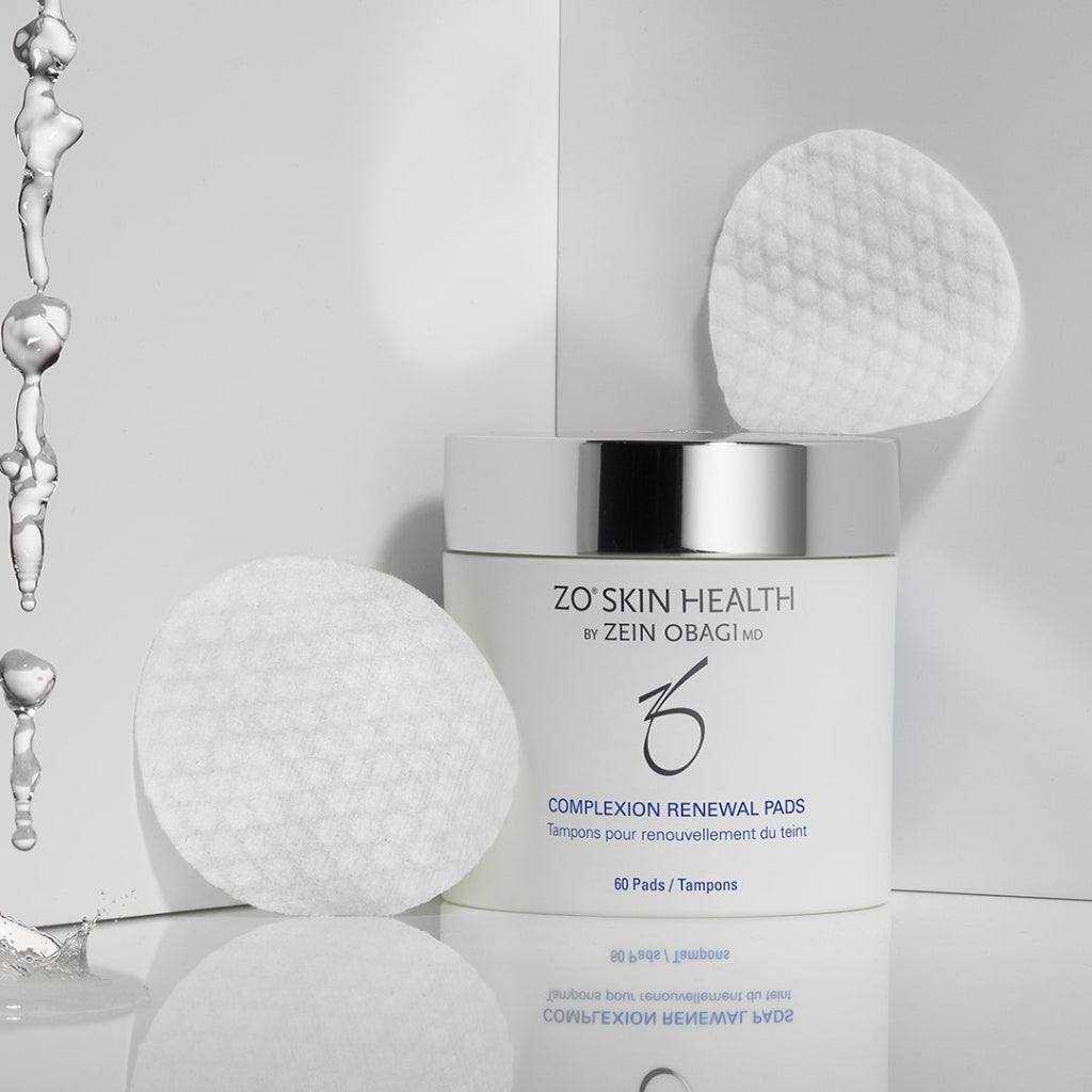 ZO Skin Health Complexion Renewal Pads jar with water droplets and two textured exfoliating pads in the background, highlighting salicylic acid formula for oily and acne-prone skin