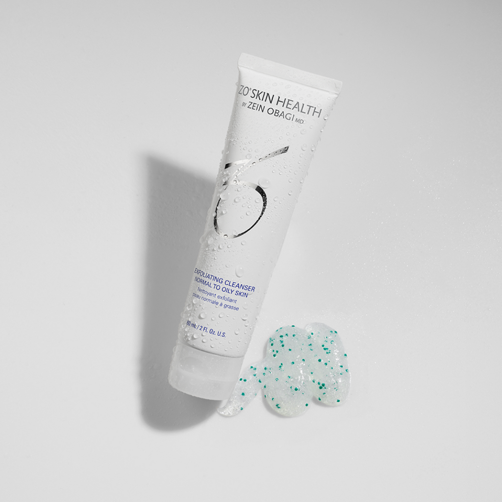 ZO Skin Health Exfoliating Cleanser 60ml travel size – white tube with water droplets shown next to a textured swatch of the gel cleanser containing green exfoliating beads, designed for normal to oily skin