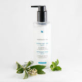 SkinCeuticals Gentle Cleanser bottle displayed among greenery and flowers, highlighting its soothing, sensitive-skin-friendly formula
