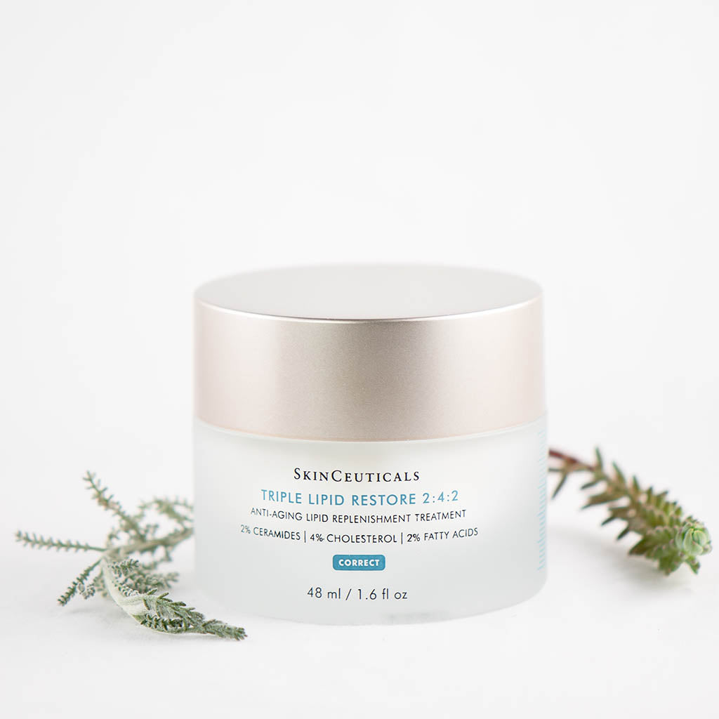 SkinCeuticals Triple Lipid Restore 2:4:2 cream displayed with green plants emphasizing nourishing, natural ingredients
