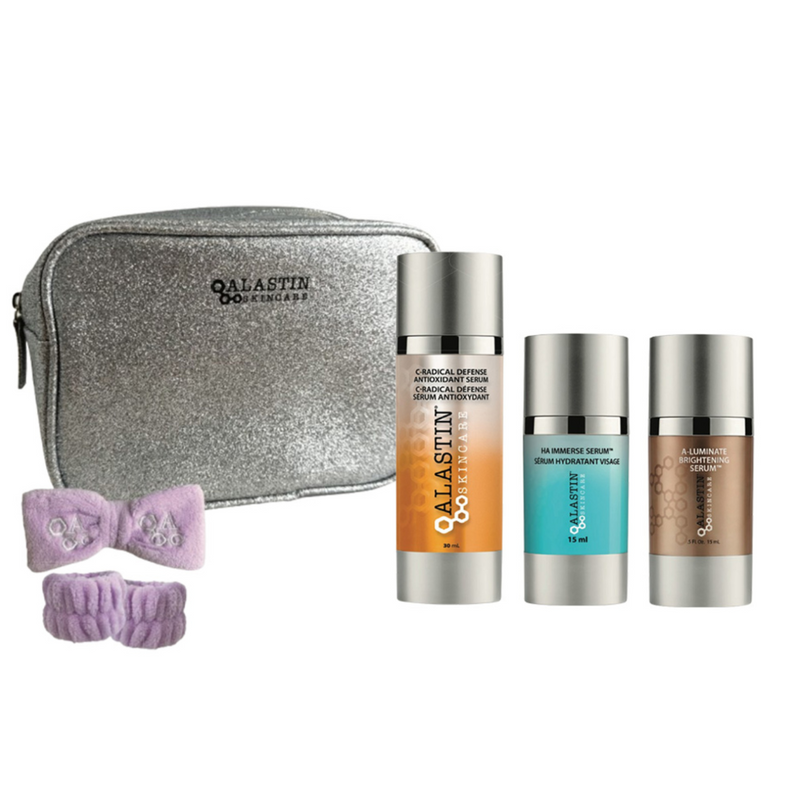 Alastin Skin Radiance Set featuring C-Radical Defense Antioxidant Serum, HA Immerse Serum, and A-Luminate Brightening Serum displayed with product bottles and packaging contents.