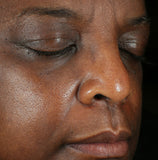 Close-up of a person's face with closed eyes on a black background