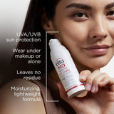 Woman holding a bottle of 'Elta MD' sunscreen with product features listed.