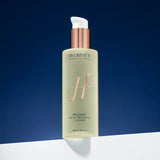 Hydrinity Prelude facial treatment cleanser bottle on a blue background standing on a white ledge