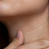 Woman touching her neck while showcasing SkinCeuticals Tripeptide-R Neck Repair anti-aging cream