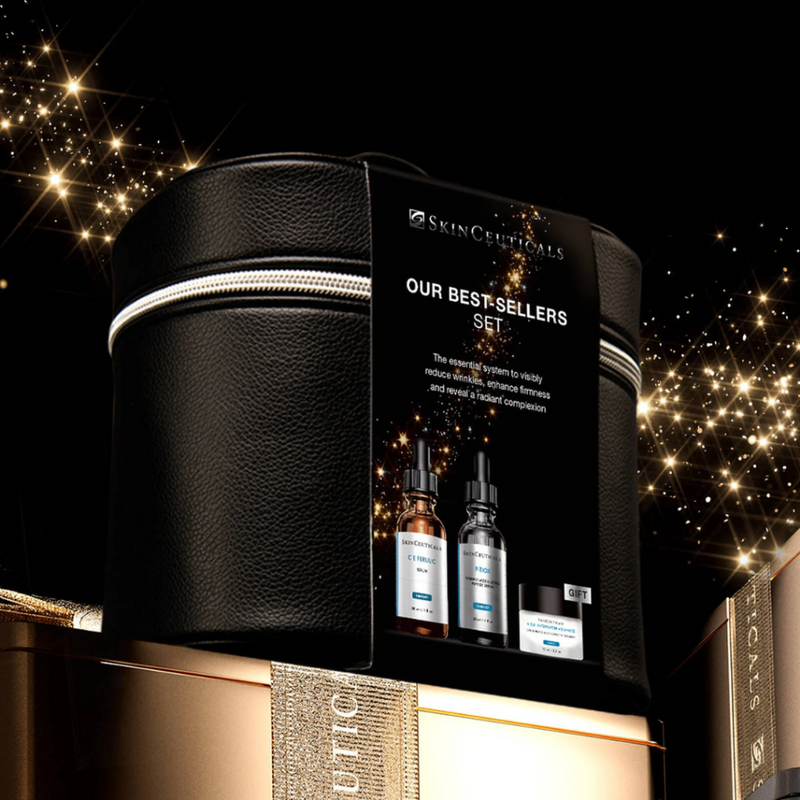 The Skinceuticals Holiday Our Best-Sellers Set displayed on top of a gold box with gold ribbon against a starry night background