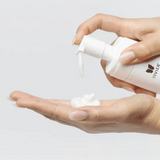 Person holding Vivier Ultra Foaming Cleanser bottle, highlighting its ergonomic design and suitability for all skin types