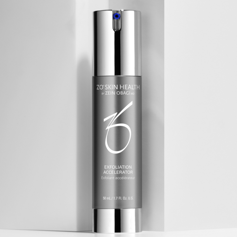 Product image of ZO Exfoliation Accelerator placed against a clean white wall background, showcasing its elegant silver and blue packaging designed to smooth skin texture, refine pores, and promote a brighter, more even complexion