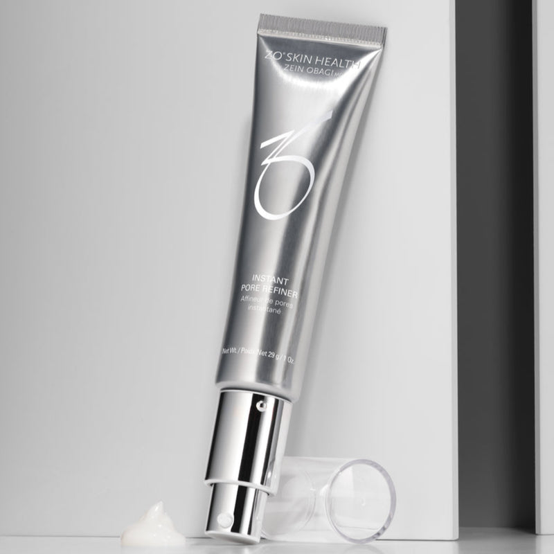 Image of ZO Instant Pore Refiner (29g) against a grey background with the cap removed, displaying a precise applicator tip and a sample swatch of the lightweight, translucent serum, emphasizing its silky, matte-finish texture