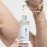 Revitalize Hair-boosting Serum bottle with a serum drip in hand