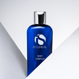 iS Clinical Body Complex bottle displayed between two modern grey diagonal boxes on a clean background
