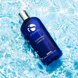 Blue skincare bottle labeled 'IS Clinical' on a water background