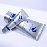 Two tubes of IS Clinical Sheald Recovery Balm on a light purple background