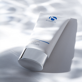 Tube of 'iS Clinical Warming Honey Cleanser on a textured white background