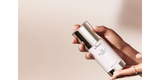 A woman elegantly holding the SkinMedica TNS Advanced+ Serum bottle, highlighting its luxurious design and ease of use for advanced anti-aging skincare