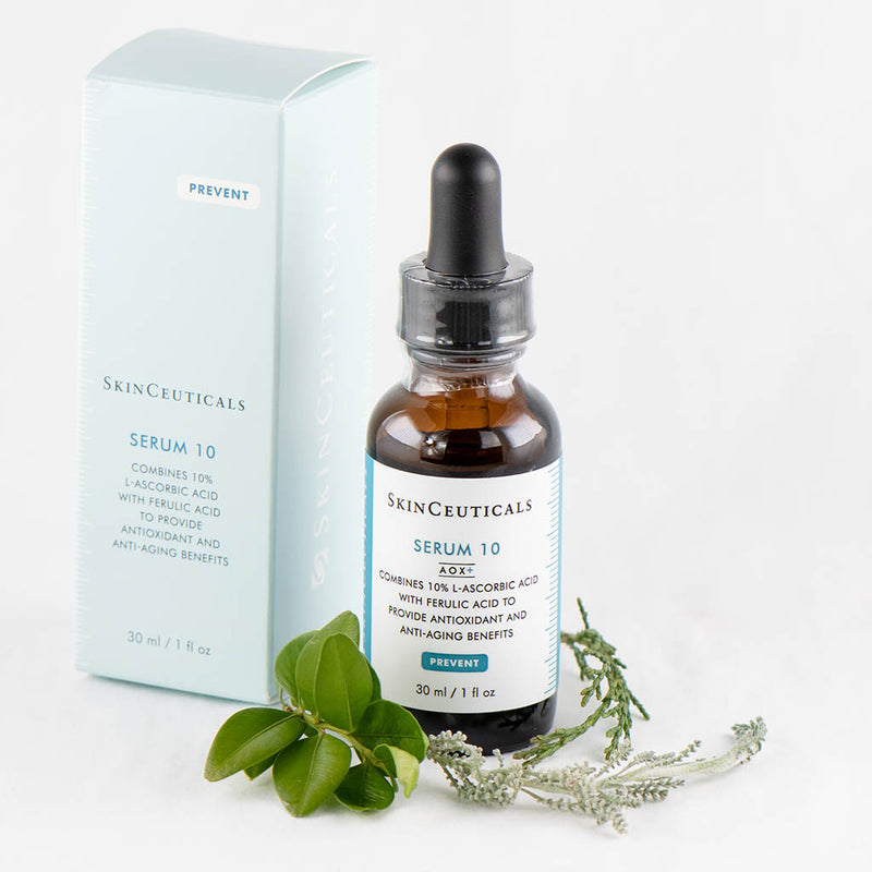 SkinCeuticals Serum 10 AOX+ bottle surrounded by delicate flowers – gentle antioxidant serum with vitamin C for sensitive skin, 30ml