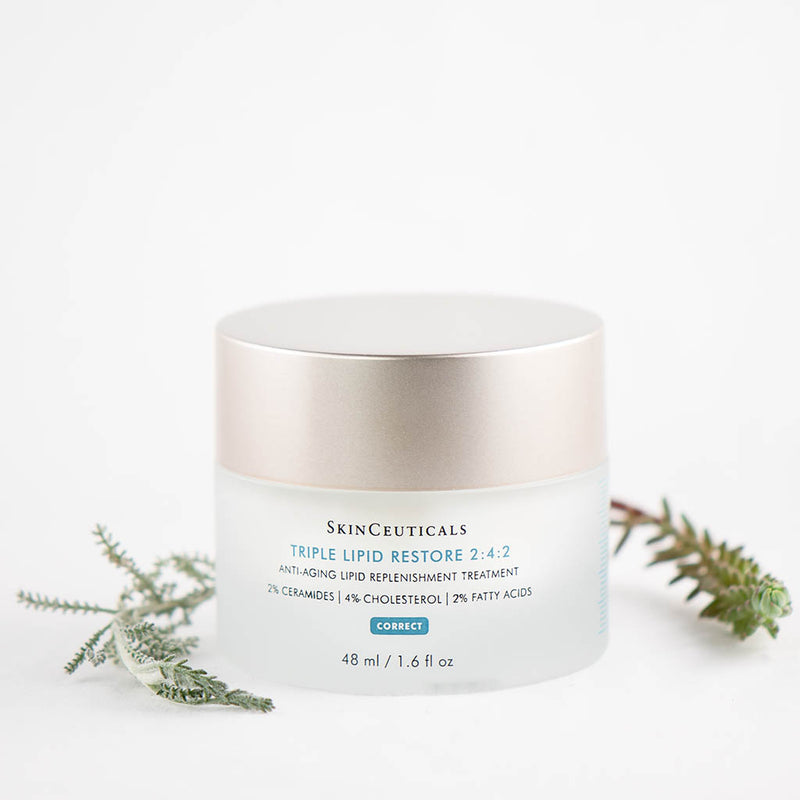 SkinCeuticals Triple Lipid Restore 2:4:2 cream displayed with green plants emphasizing nourishing, natural ingredients