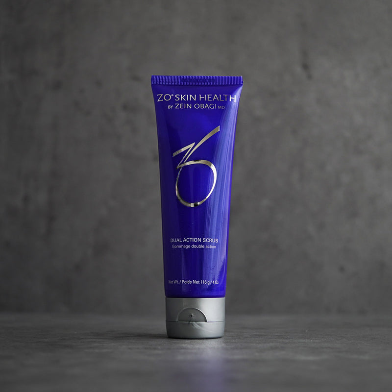 ZO Skin Health Dual Action Scrub 116g tube displayed on a grey background, featuring salicylic acid and exfoliating beads for smoother, clearer skin and refined pores