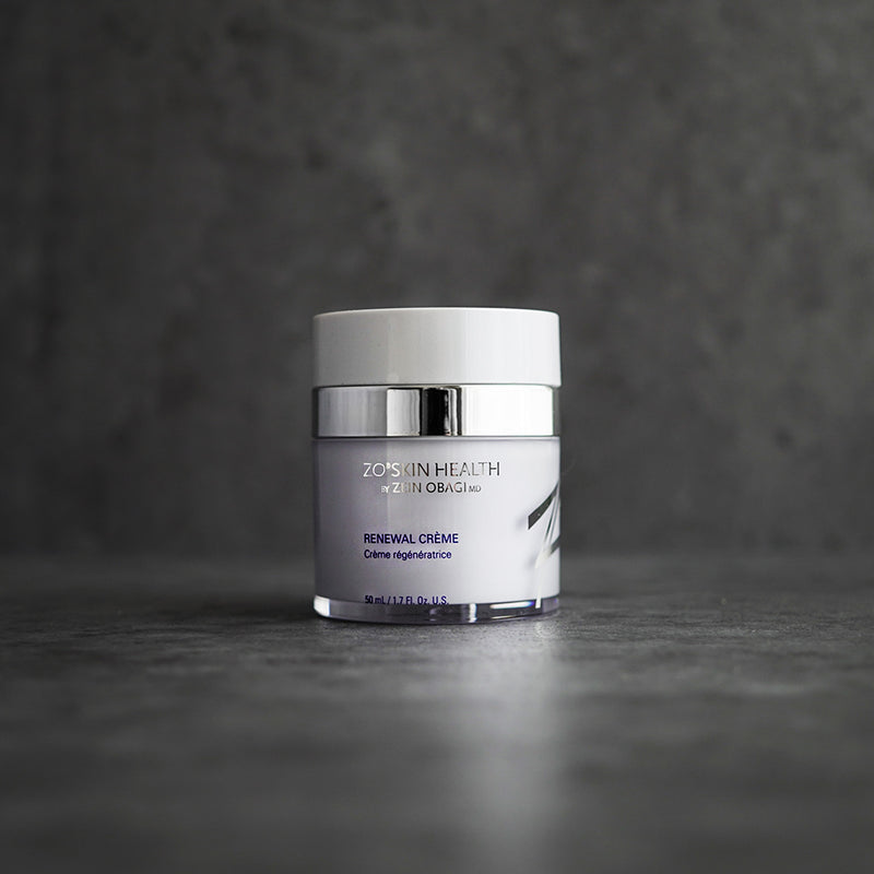 ZO Renewal Crème 50ml jar placed on a grey concrete surface, showcasing a sleek and minimal aesthetic