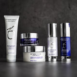 ZO Skin Brightening Program kit arranged on a grey concrete background, featuring a comprehensive set of products to diminish discoloration and enhance skin radiance.